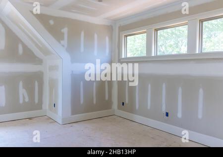 Finishing plastering drywall in ready for paint with new house Stock Photo