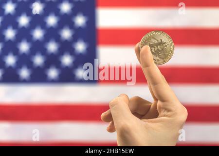 Man holds bitcoin against American flag background photo Stock Photo