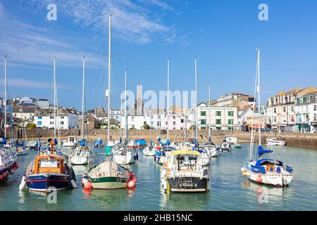 Ilfracombe beach behind the fishing boats and yachts in the harbour in  the town of Ilfracombe Devon England UK GB Europe Stock Photo