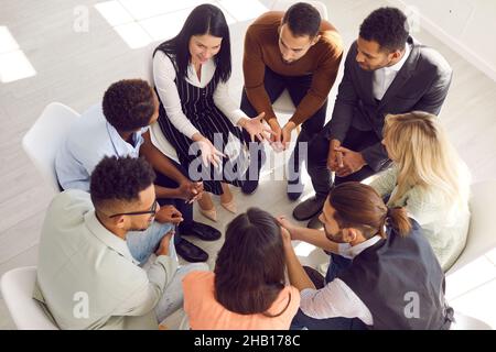 Diverse people sit in circle engaged in teambuilding activity Stock Photo