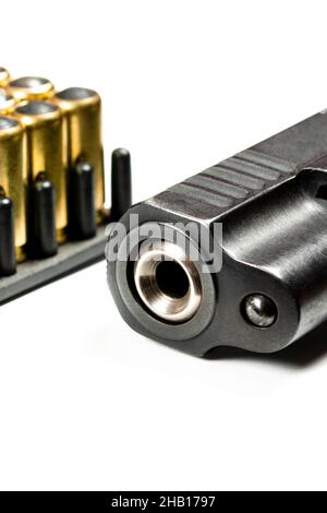 photo of a black pistol and bullets on a white background. Weapons Stock Photo