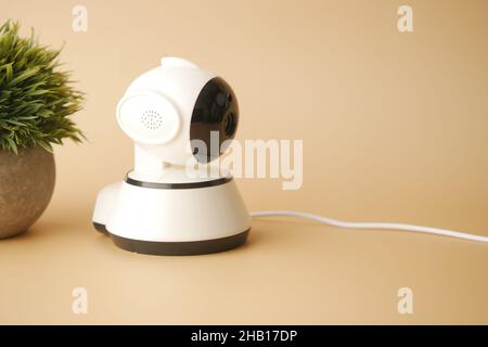 CCTV security camera operating on light orange background  Stock Photo