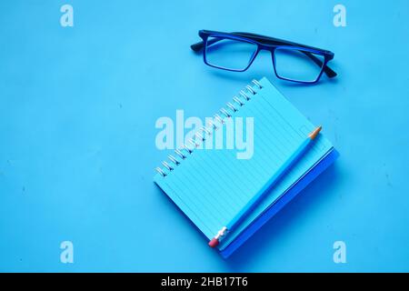 high angle view of blue color notepad with pencil on blue desk  Stock Photo