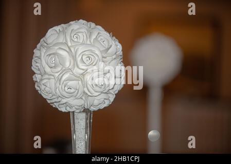 Artificail white flower ball with small diamonds in glass vase table decore with warm bokeh background Stock Photo