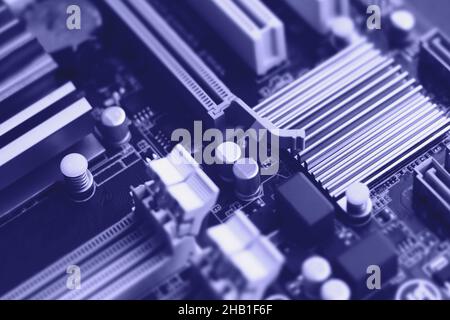 Defocused trendy very peri color concept of the year 2022, violet blue, lavender computer motherboard closeup background. Selective focus Stock Photo