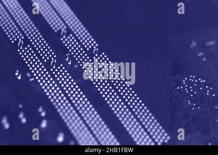 Defocused trendy very peri color concept of the year 2022, violet blue, lavender computer motherboard closeup background. Selective focus Stock Photo