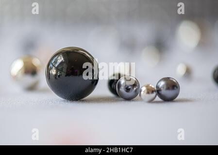 Shiny arbles of various colors black, grey, gold in a group on white surface abstract Stock Photo