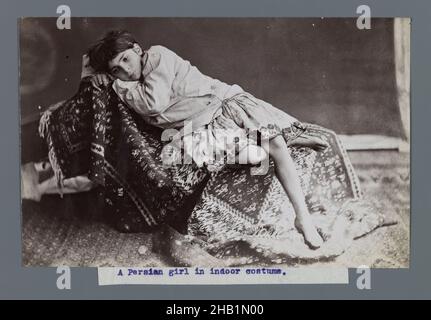 Young Girl Lying Down on Kilim, One of 274 Vintage Photographs, Albumen silver photograph, late 19th-early 20th century, Qajar, Qajar Period, 4 7/8 x 7 5/8 in., 12.4 x 19.3 cm, 19th century, black and white, carpet, child, dress, girl, historical fashion, Iran, Persian, Persian Rug, photograph, photography, rug Stock Photo
