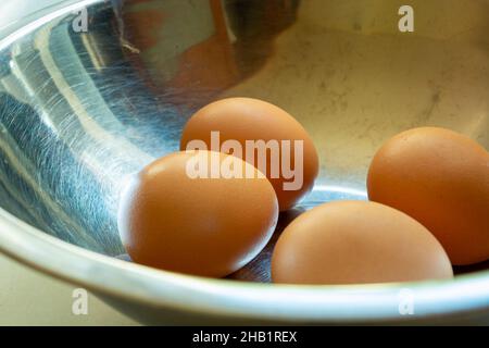Raw eggs in shells in a silver bowl, close up Stock Photo