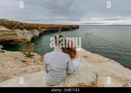 Couple hold each other looking over Lake Superior, Michigan Stock Photo