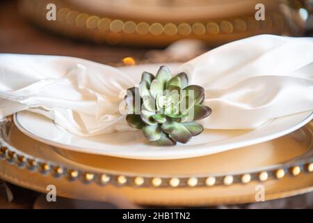 White linen napkin flower napkin ring on gold charger plates Stock Photo