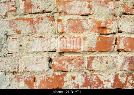Wall of old red bricks and cement plaster, background Stock Photo