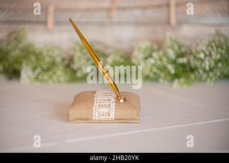 Burlap and lce. pen holder with gold pen at wedding guest sign in table Stock Photo