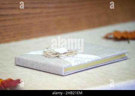 Grey burlap and lace with bow guest sign in book at fall wedding reception Stock Photo