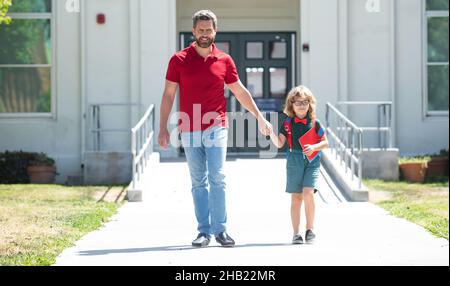 Outdoor school. School boy going to school with father. Parent with child in front of School gates. Stock Photo