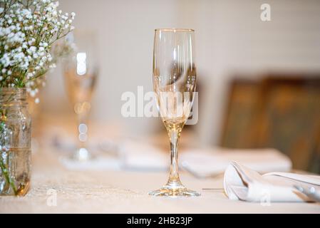 Champagne filled glasses lined up and ready to serve at wedding reception table Stock Photo