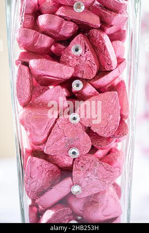 Heart shaped chocolate candies wrapped in pink aluminum foil at dessert bar Stock Photo