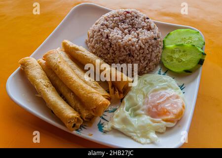 Breakfast in Philippines - rice with fried rolls (lumpia) and egg Stock Photo