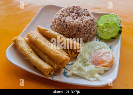 Breakfast in Philippines - rice with fried rolls (lumpia) and egg Stock Photo