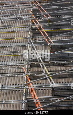 scaffolding and ladders on a building for maintenance work on a multi-storey block of flats or apartments, ladders and scaffolding to replace cladding Stock Photo