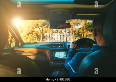 Man driving right-hand drive car and using navigation system Stock Photo