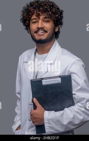 Cheerful doctor with documents looking in front of him Stock Photo