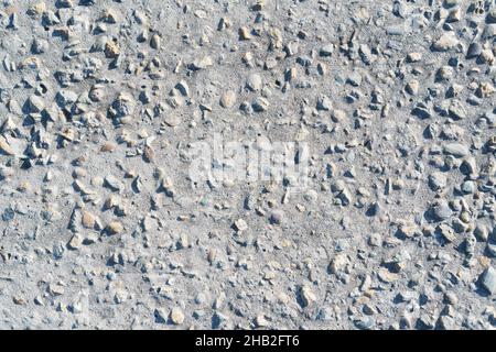 The texture of a concrete road with stones and cracks in full screen. As background Stock Photo