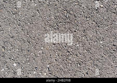 The texture of a concrete road with stones and cracks in full screen. As background Stock Photo