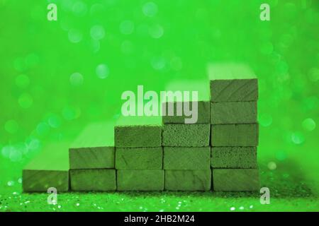 Podium for product presentation. Minimalistic staircase made of wooden cubes. A scene with geometric shapes. On a shiny green background. High quality photo Stock Photo