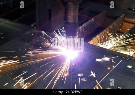 Plasma cutting of metal with CNC, modern industrial technologies. Warning - accurate shooting in difficult conditions. Stock Photo