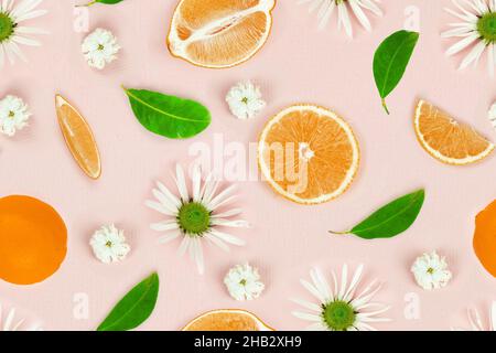 Seamless pattern of sliced lemon with fresh chamomile flowers on pink background. Top view, flat lay, design element. Creative summer minimalistic bac Stock Photo