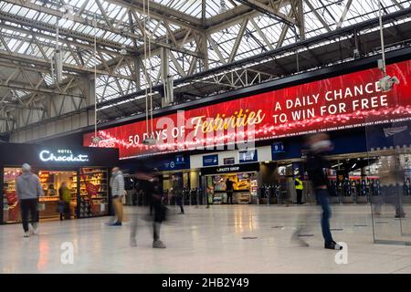 People at Waterloo train station, London UK in December - long exposure travellers rushing hurrying concept Stock Photo