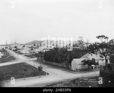 Noumea, Burton Brothers studio, photography studio, 1899, Dunedin, black-and-white photography, Panorama of township with streets running across from right to left and perpendicular. A street lamp is on the corner. Tropical foliage including coconut and palm trees amongst colonial buildings with harbour to left and behind, tall ships masts visible Stock Photo