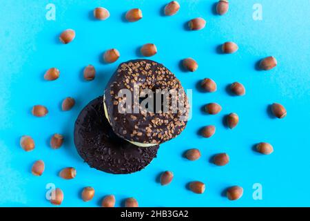 Donut with hazelnuts on a blue background, close up Stock Photo