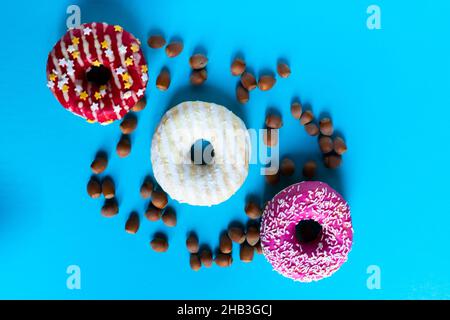 Donut with hazelnuts on a blue background, close up Stock Photo