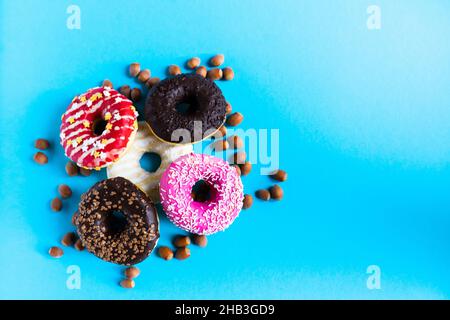 Donut with hazelnuts on a blue background, close up Stock Photo