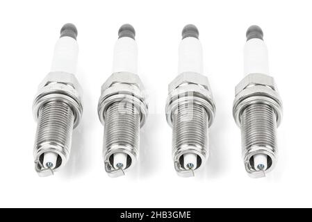 Four iridium spark plugs in a row isolated on white background with clipping path Stock Photo