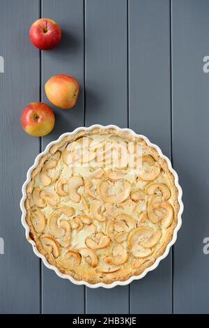 Apple tart with whole apples on grey stripped background vertical Stock Photo