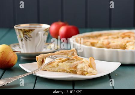 Apple tart with cup of tea and three whole apples horizontal Stock Photo