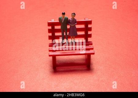 View of a man and a woman standing on a bench., symbolic photo with miniature figurines