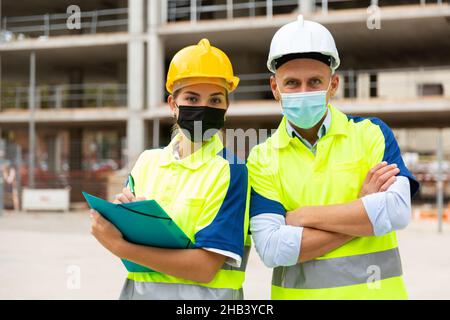 Civil engineers in masks checking work process Stock Photo