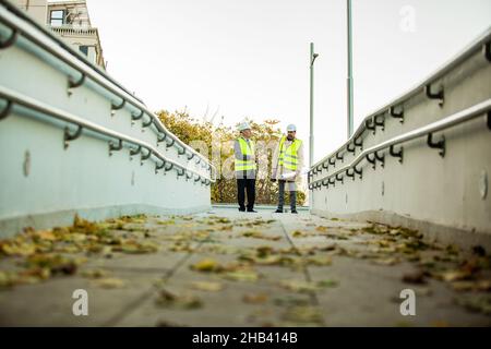 Two senior construction managers are standing and having a conversation Stock Photo
