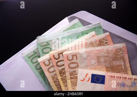 Several € 50 and € 100 euro bills inside a white envelope. Conceptual image referring to payments in B, corruption and underground economy Stock Photo