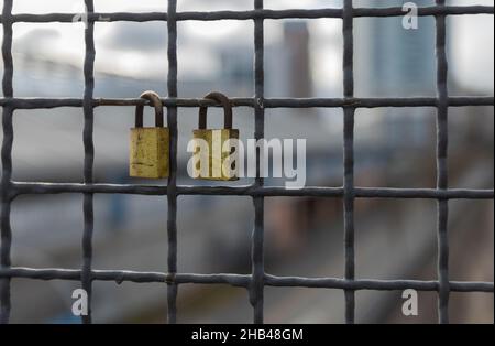 Padlocks hanging on a wire rope. Love locks on netting fence at the brigde in New Wesminster BC. Stock Photo