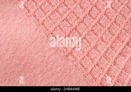 Pink knitted carpet close up. Textile texture detailed warm yarn background. Stock Photo