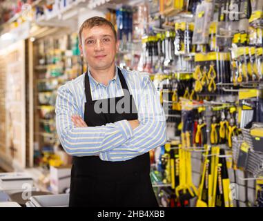 Man seller in apron having tools in hands Stock Photo