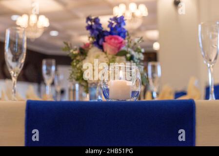 Glass round candle holder with lit white candle Stock Photo