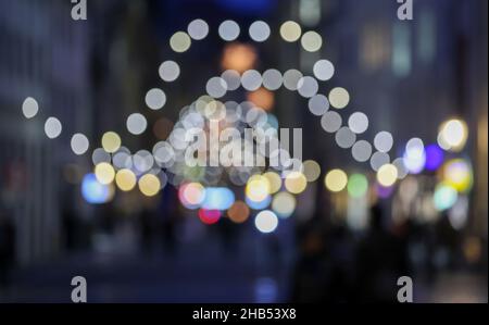 Leipzig, Germany. 15th Dec, 2021. Fairy lights adorn Nikolaistrasse in Leipzig's city centre. At Christmas time, the Transport and Public Works Department installs around 5,300 lamps in the streets and alleys of the city centre in addition to the public lighting. More than half of these are now energy-efficient LED lamps. Garlands of lights, Herrnhut stars and other Christmas motifs create a festive atmosphere. Along the Promenadenring there are around 174 fairy lights. Credit: Jan Woitas/dpa-Zentralbild/ZB/dpa/Alamy Live News Stock Photo