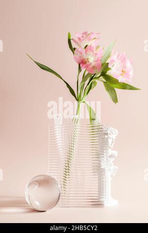 flower in vase through textured glass with decorative elements on beige background. minimalistic, trend and textured background. wabi sabi concept. Stock Photo