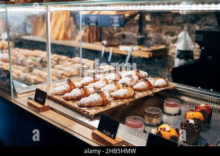 Various cakes are on plates in a display case Stock Photo